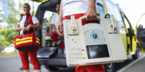 técnicos de emergencias delante de una ambulancia